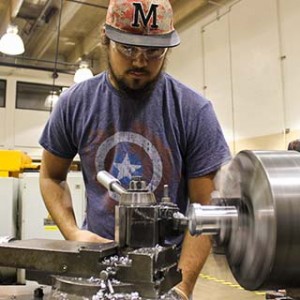 Male working at a manual lathe